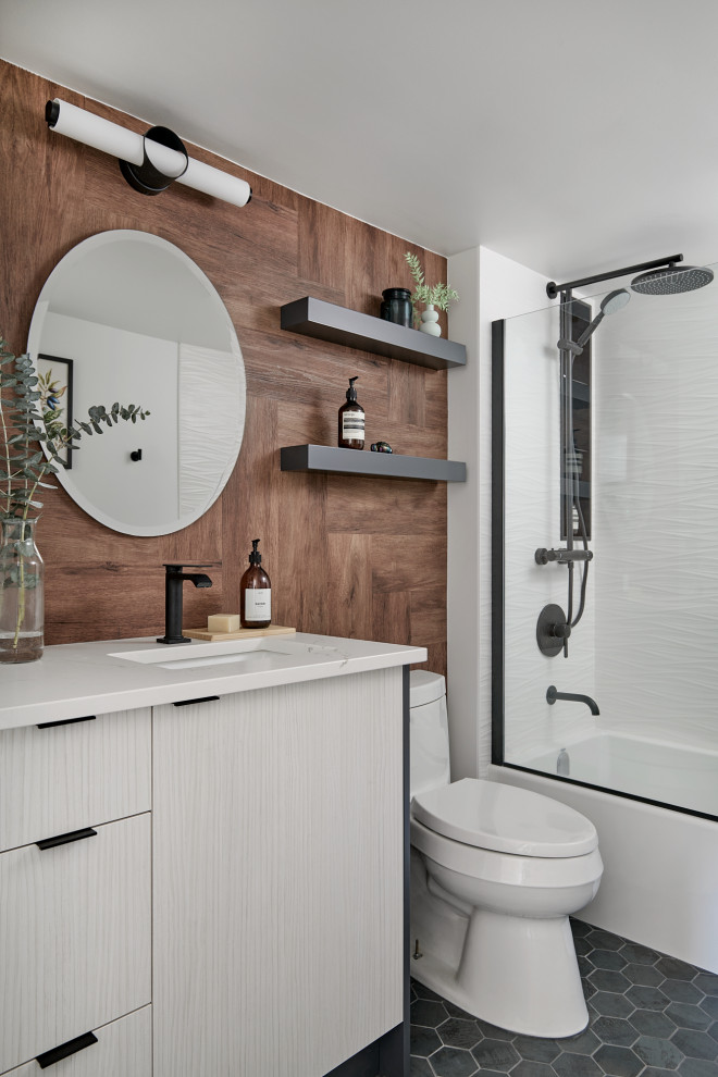 Пример оригинального дизайна: маленькая ванная комната в стиле модернизм с плоскими фасадами, светлыми деревянными фасадами, ванной в нише, душем в нише, унитазом-моноблоком, коричневой плиткой, белыми стенами, полом из керамогранита, врезной раковиной, столешницей из кварцита, серым полом, бежевой столешницей, тумбой под одну раковину, напольной тумбой и деревянными стенами для на участке и в саду
