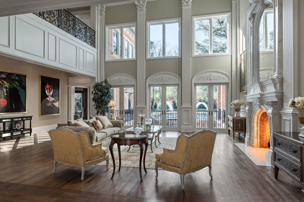 Photo of a large traditional formal enclosed living room in Dallas with beige walls, dark hardwood floors, a standard fireplace, no tv and a plaster fireplace surround.