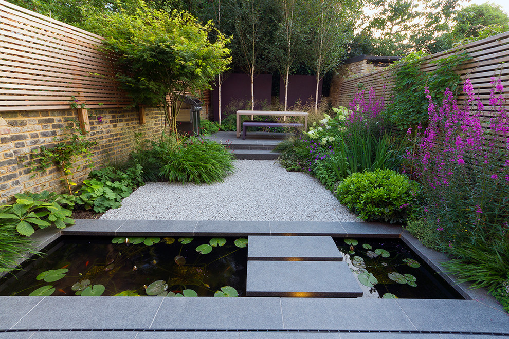 Design ideas for a small modern backyard garden in London with a water feature and natural stone pavers.