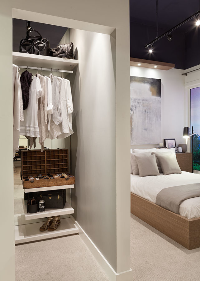 Inspiration for a small modern gender-neutral walk-in wardrobe in Vancouver with white cabinets and carpet.