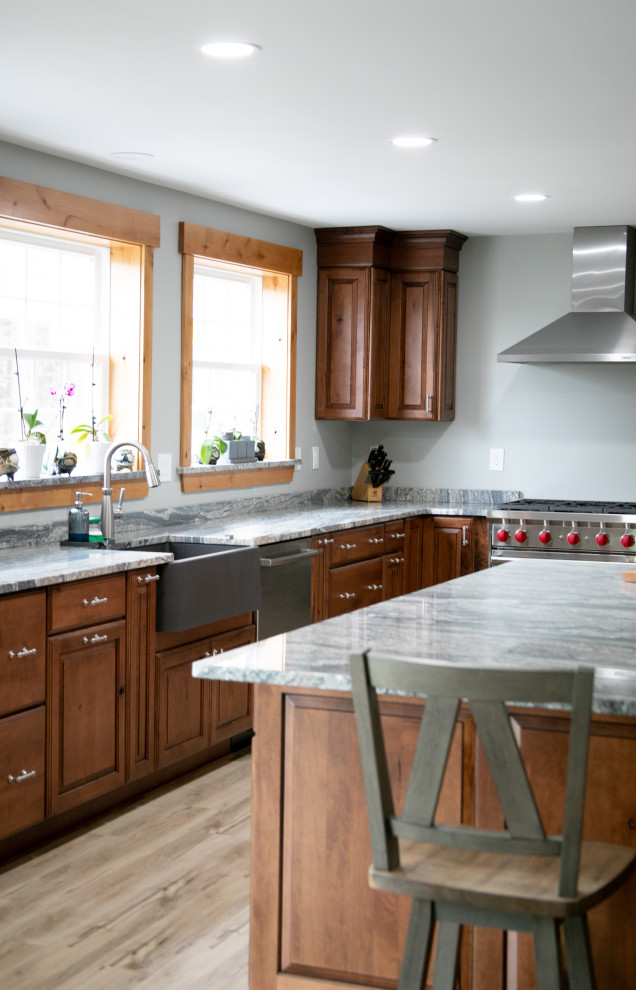 Inredning av ett rustikt stort grå grått kök, med en rustik diskho, luckor med upphöjd panel, skåp i mörkt trä, marmorbänkskiva, rostfria vitvaror, vinylgolv, en köksö och beiget golv