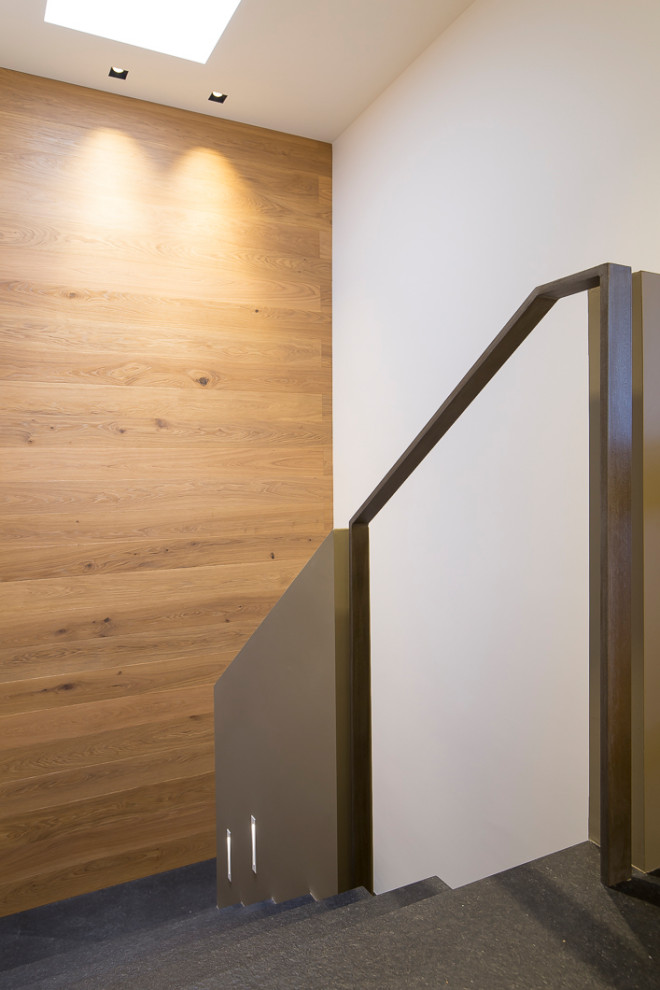 Large modern slate u-shaped staircase in Other with slate risers, metal railing and wood walls.