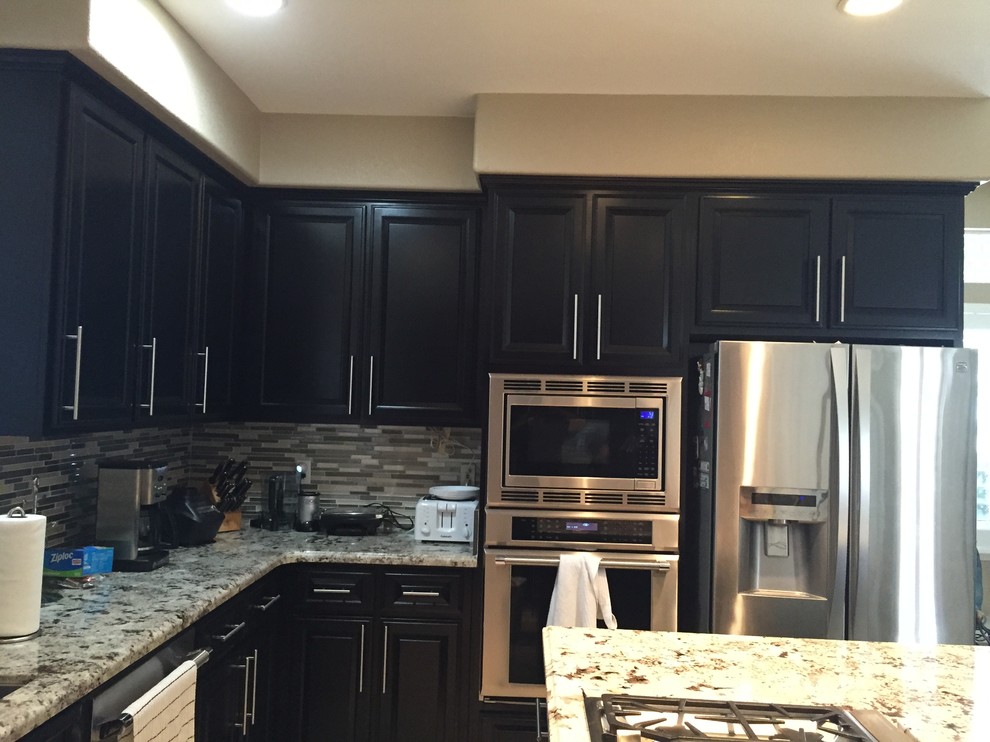 This is an example of a mid-sized contemporary u-shaped eat-in kitchen in Sacramento with an undermount sink, shaker cabinets, dark wood cabinets, stainless steel benchtops, metallic splashback, matchstick tile splashback, stainless steel appliances, ceramic floors, with island and beige floor.