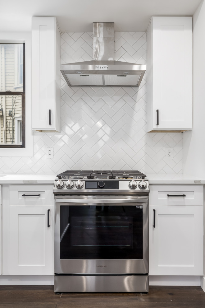 Eat-in kitchen - large transitional u-shaped dark wood floor and brown floor eat-in kitchen idea in Minneapolis with a single-bowl sink, shaker cabinets, white cabinets, quartz countertops, white backsplash, ceramic backsplash, stainless steel appliances, an island and white countertops