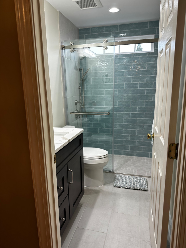 На фото: маленькая детская ванная комната в стиле неоклассика (современная классика) с плоскими фасадами, серыми фасадами, душем без бортиков, раздельным унитазом, синей плиткой, керамической плиткой, бежевыми стенами, полом из керамогранита, врезной раковиной, столешницей из искусственного кварца, бежевым полом, душем с раздвижными дверями, белой столешницей, нишей, тумбой под одну раковину и встроенной тумбой для на участке и в саду