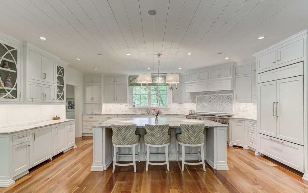 Example of a transitional u-shaped light wood floor and beige floor open concept kitchen design in Baltimore with an undermount sink, recessed-panel cabinets, white cabinets, marble countertops, gray backsplash, marble backsplash, paneled appliances, an island and gray countertops
