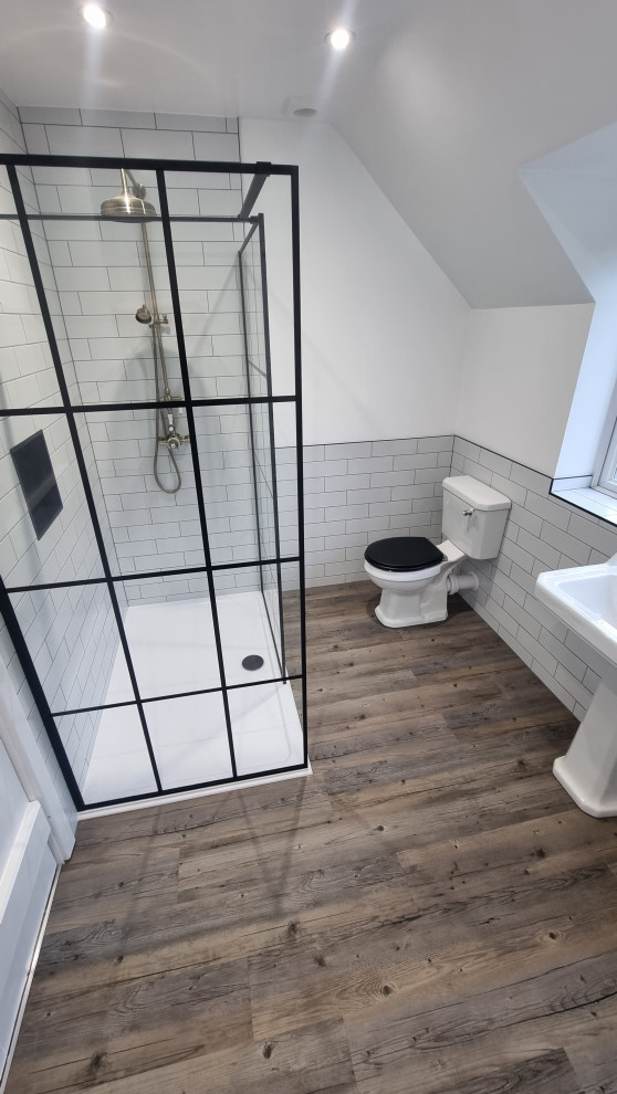 Photo of a large traditional master bathroom in West Midlands with an open shower, a two-piece toilet, white tile, ceramic tile, white walls, vinyl floors, a pedestal sink, multi-coloured floor, an open shower, a niche and a single vanity.