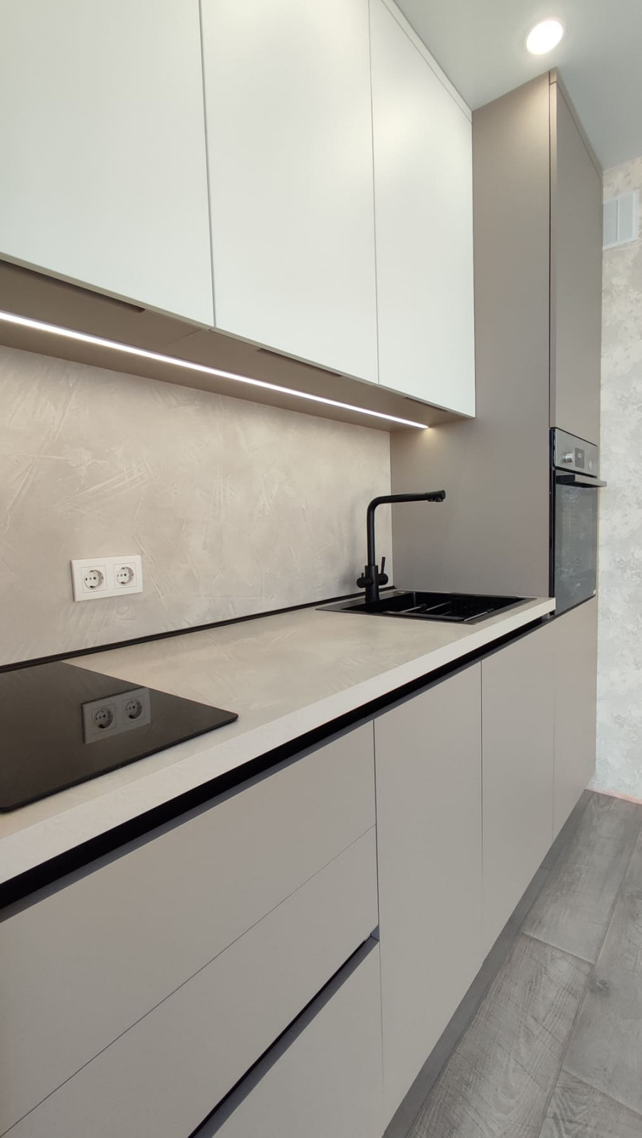 Небольшая встроенная кухня в серо-белом цвете с однотонными фасадами