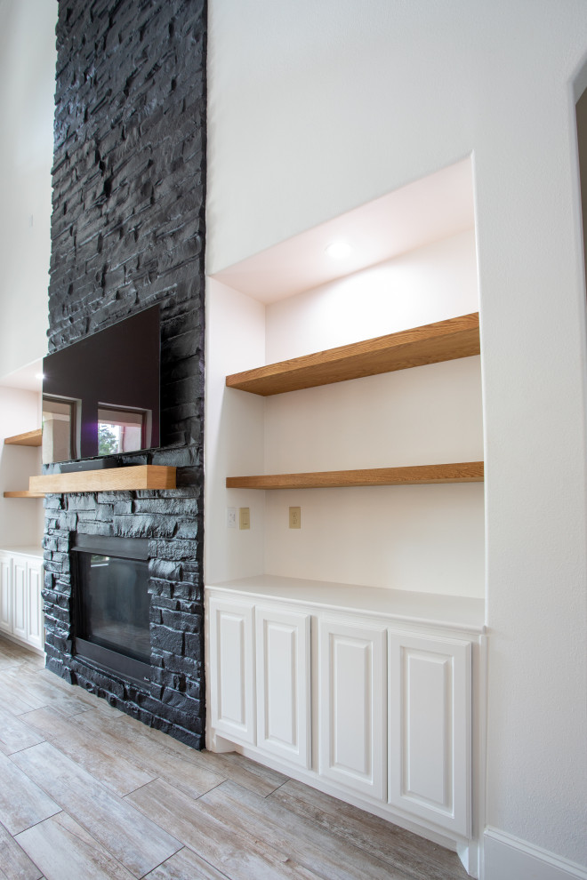Idée de décoration pour un grand salon minimaliste ouvert avec un mur noir, une cheminée standard, un manteau de cheminée en brique et un téléviseur indépendant.