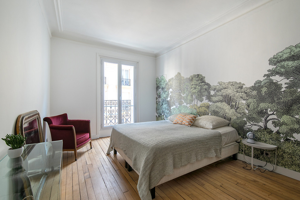 Mid-sized transitional master bedroom in Paris with white walls, light hardwood floors and brown floor.