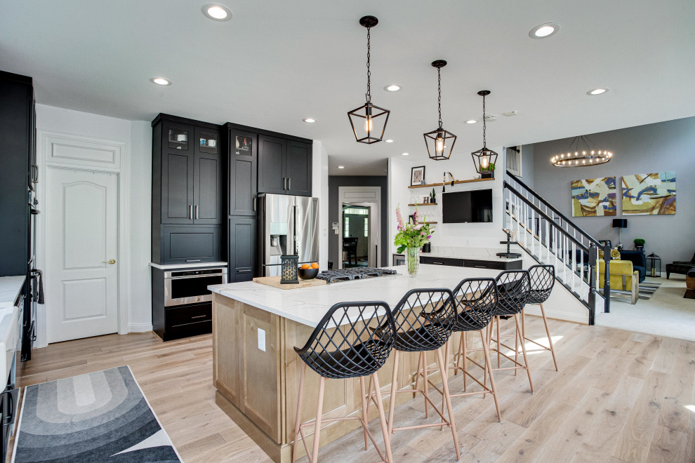Example of a large transitional u-shaped eat-in kitchen design in DC Metro with a farmhouse sink, quartz countertops, stainless steel appliances and an island