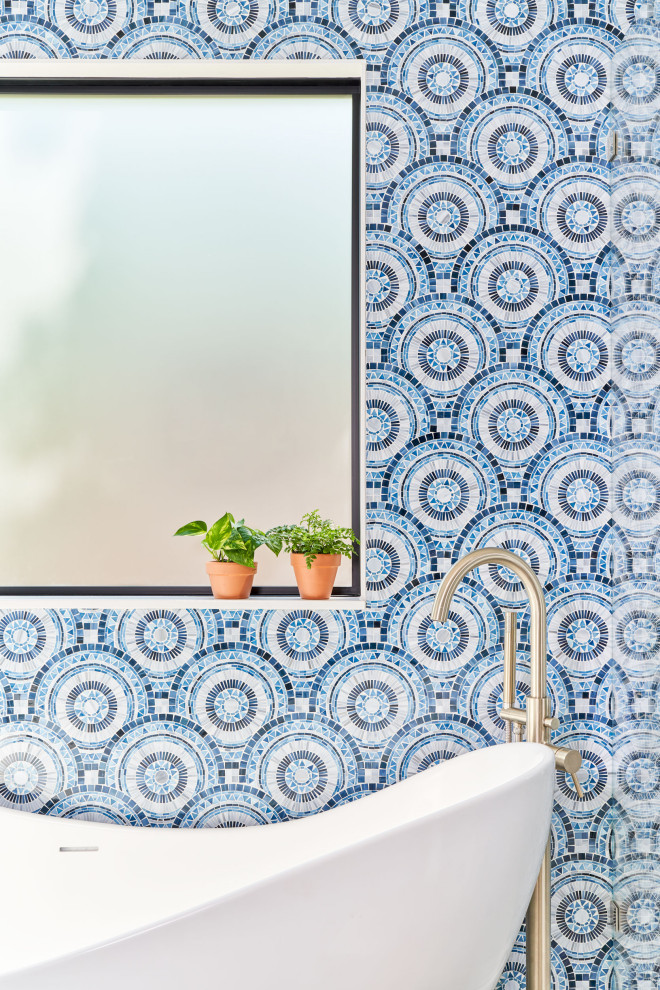 Foto de cuarto de baño principal actual con bañera exenta, baldosas y/o azulejos azules, baldosas y/o azulejos de vidrio y paredes azules