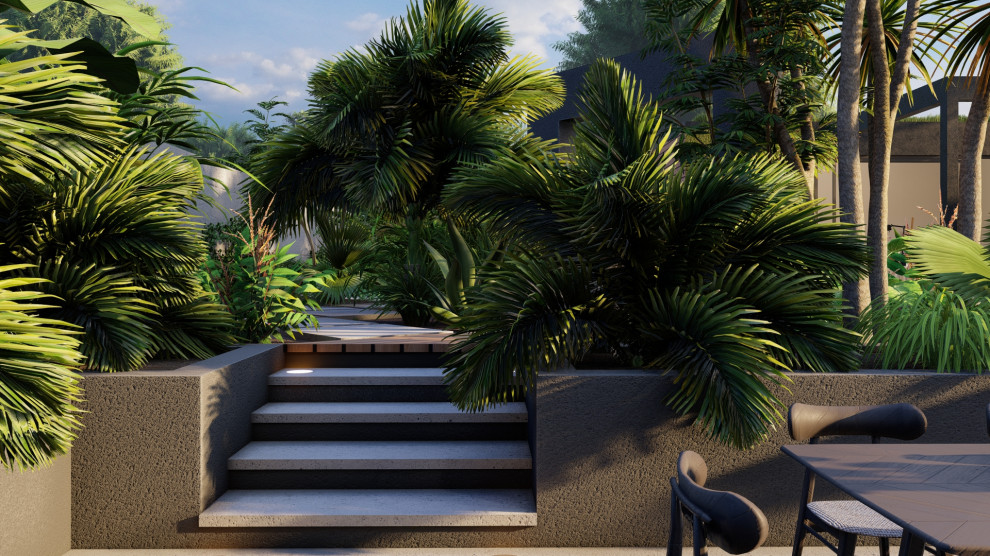 Esempio di un grande giardino formale tropicale esposto a mezz'ombra dietro casa in estate con fontane, pavimentazioni in cemento e recinzione in pietra