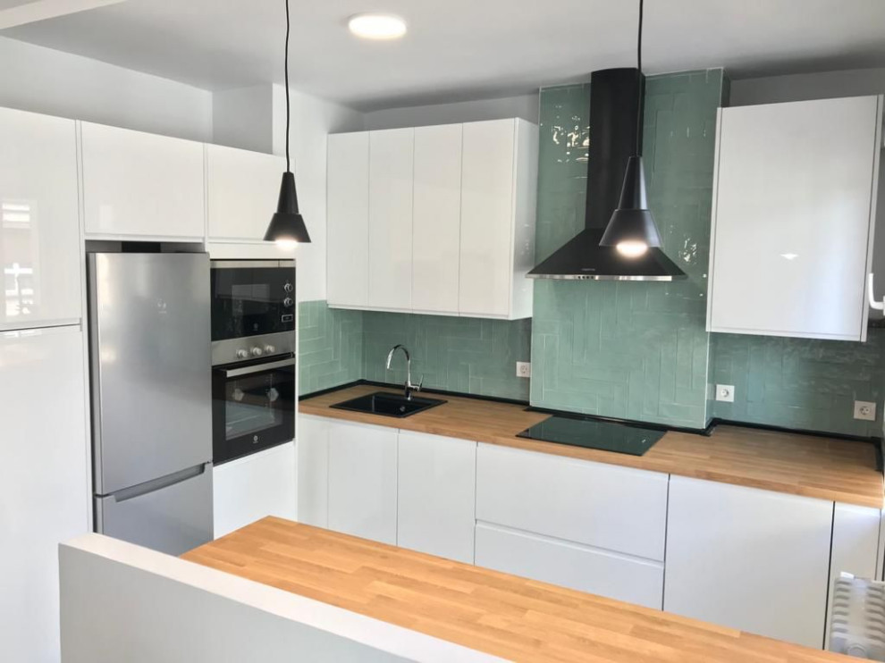 Inspiration for a mid-sized contemporary u-shaped kitchen in Other with a farmhouse sink, flat-panel cabinets, white cabinets, laminate benchtops, green splashback, ceramic splashback, white appliances, cement tiles, with island, grey floor and brown benchtop.