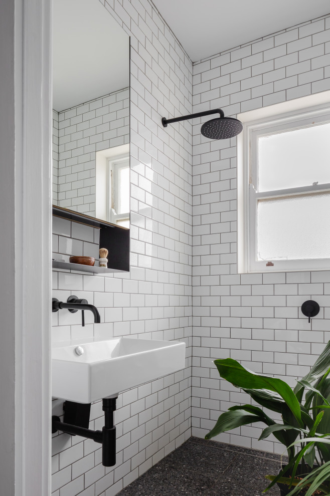 Kleines Duschbad mit offener Dusche, Wandtoilette, weißen Fliesen, Keramikfliesen, weißer Wandfarbe, Terrazzo-Boden, Wandwaschbecken, grauem Boden, offener Dusche und Einzelwaschbecken in Sydney