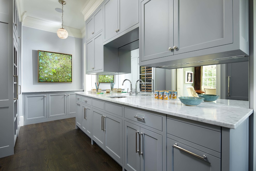 Photo of a mid-sized traditional single-wall wet bar in Minneapolis with shaker cabinets, grey cabinets, mirror splashback, dark hardwood floors, brown floor and white benchtop.