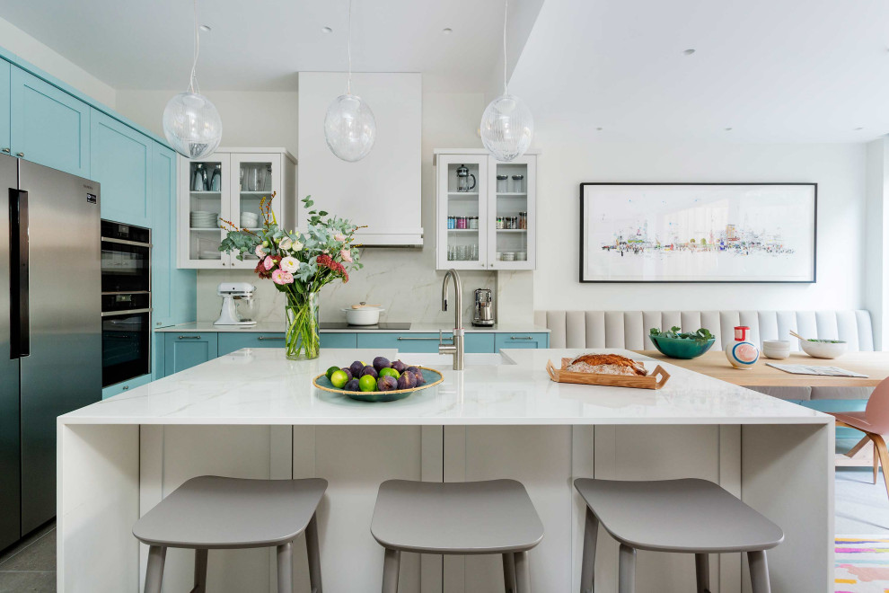 Inspiration for a large contemporary kitchen in London with shaker cabinets, marble worktops, marble splashback and an island.