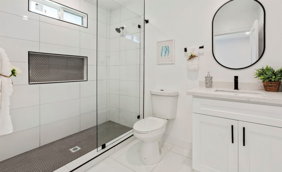 Inspiration for a bathroom in Los Angeles with shaker cabinets, white cabinets, an alcove shower, a one-piece toilet, white walls, ceramic flooring, a submerged sink, marble worktops, white floors, an open shower, white worktops, a wall niche, a single sink and a built in vanity unit.