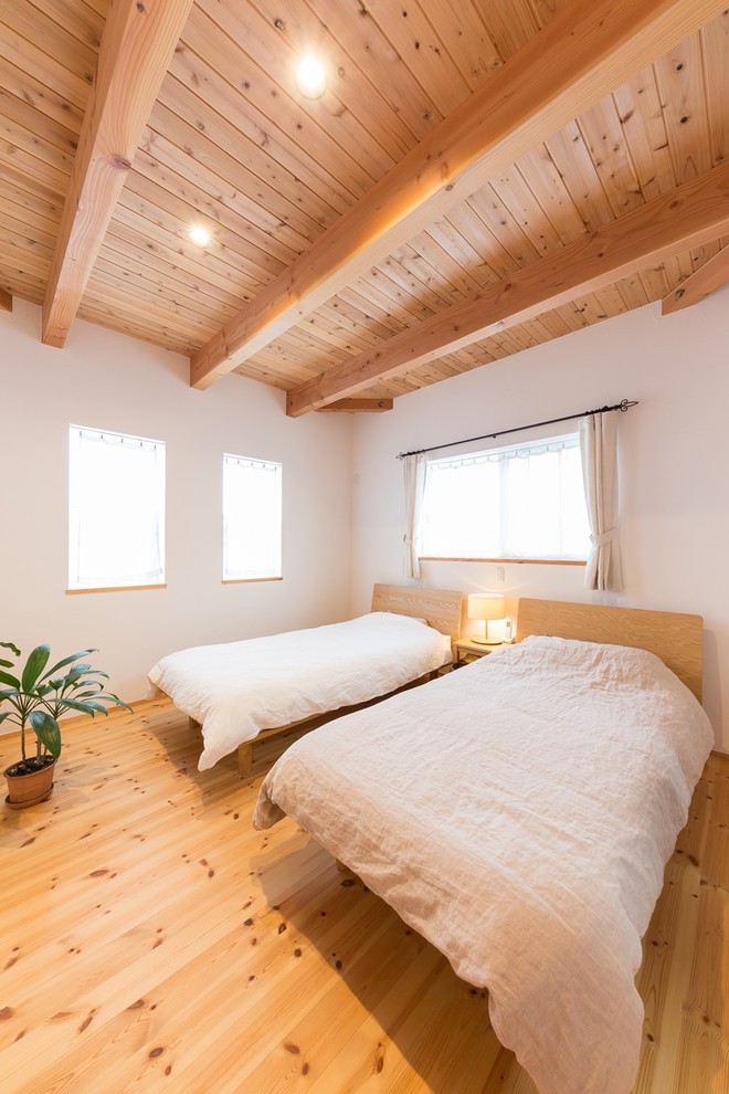 Idées déco pour une chambre asiatique avec un mur blanc, un sol en bois brun et un sol marron.