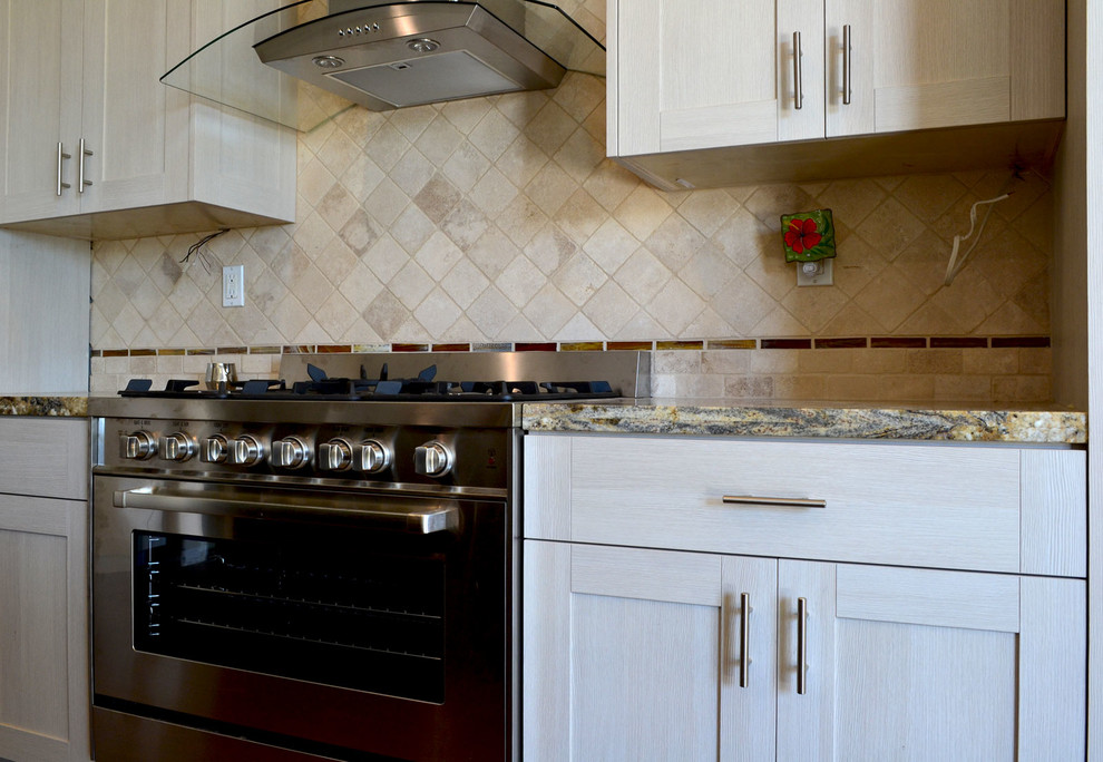 Photo of a contemporary kitchen in Los Angeles with shaker cabinets, white cabinets, granite benchtops, stainless steel appliances, with island, beige splashback and cement tile splashback.