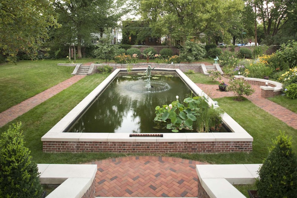 This is an example of a large traditional courtyard pool in Minneapolis with brick pavers.