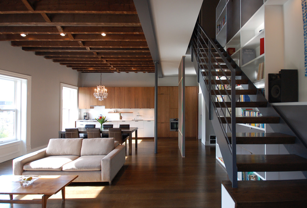 This is an example of a large modern wood floating staircase in New York with open risers and cable railing.