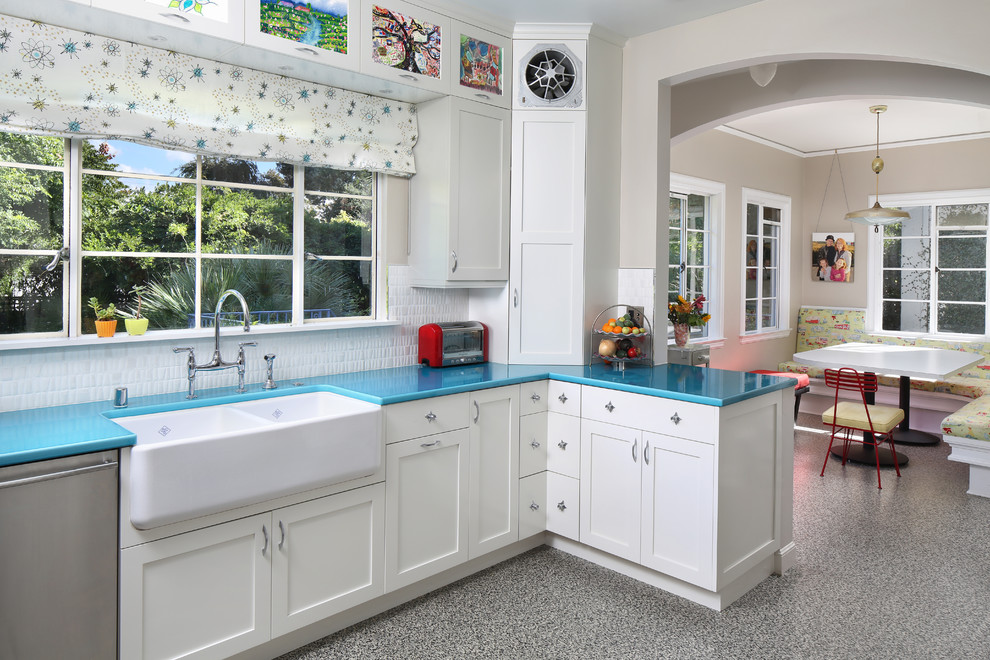 Photo of a mid-sized transitional u-shaped separate kitchen in San Diego with a farmhouse sink, shaker cabinets, white cabinets, white splashback, stainless steel appliances, linoleum floors and turquoise benchtop.
