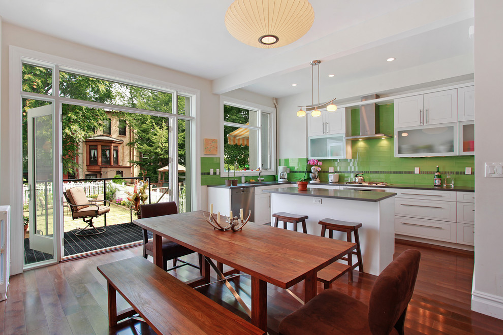 This is an example of a transitional kitchen/dining combo in New York with white walls and dark hardwood floors.