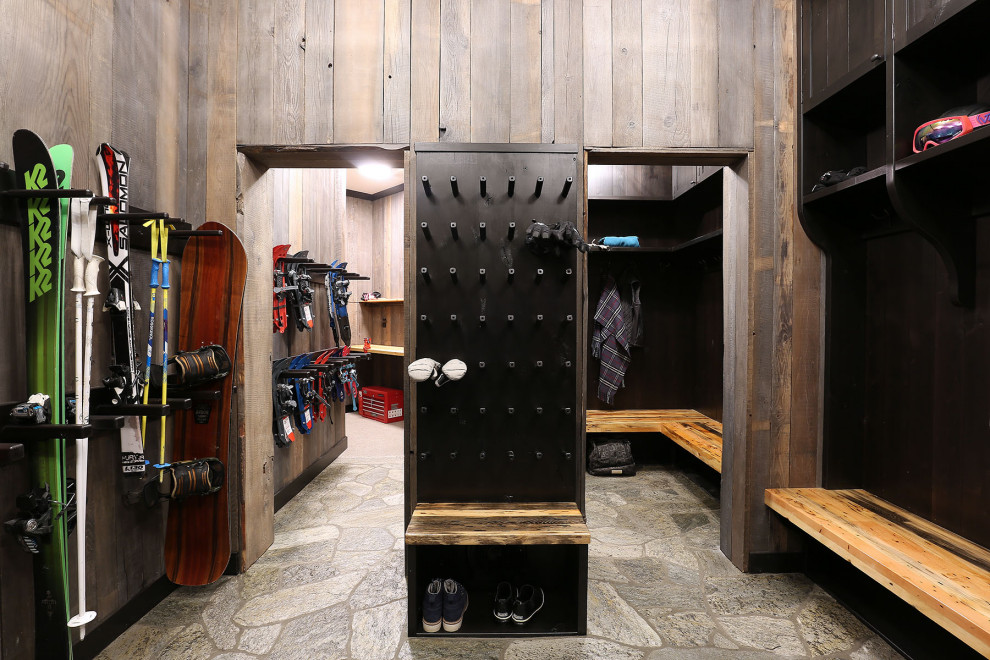Example of a large mountain style gray floor mudroom design with a dark wood front door