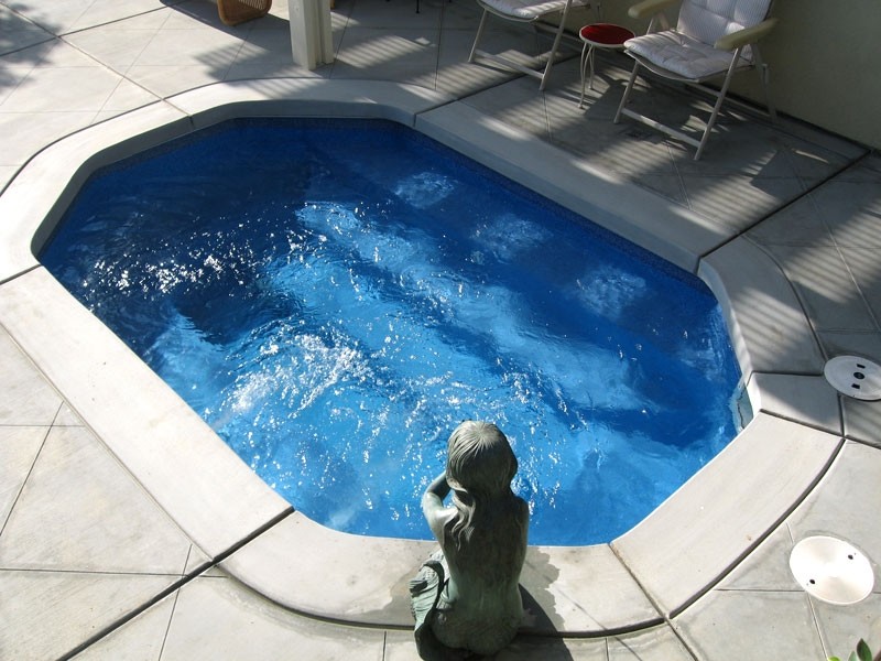 Backyard stone and custom-shaped hot tub photo