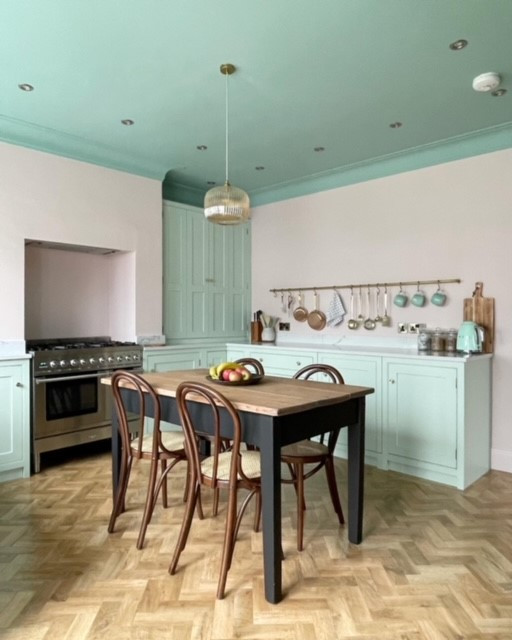 This is an example of a mid-sized traditional separate kitchen in Surrey with beaded inset cabinets, green cabinets and white benchtop.