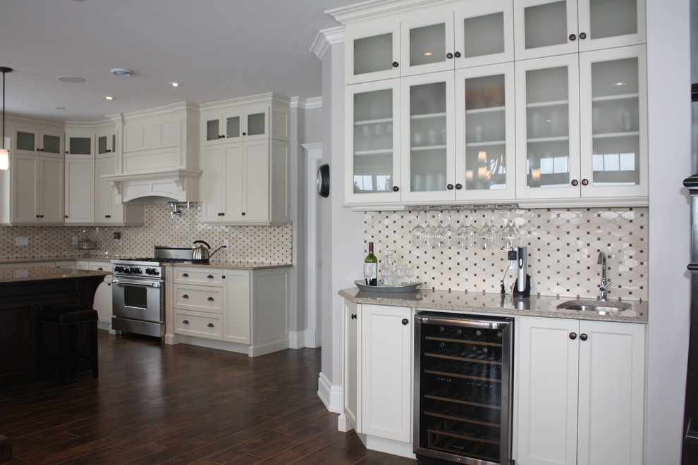 Example of a large classic l-shaped medium tone wood floor eat-in kitchen design with an island, recessed-panel cabinets, yellow cabinets, quartz countertops, black backsplash, cement tile backsplash, stainless steel appliances and a farmhouse sink