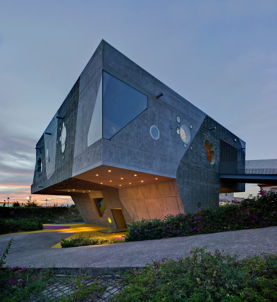 This is an example of a large contemporary two-storey concrete grey house exterior in Other with a flat roof.