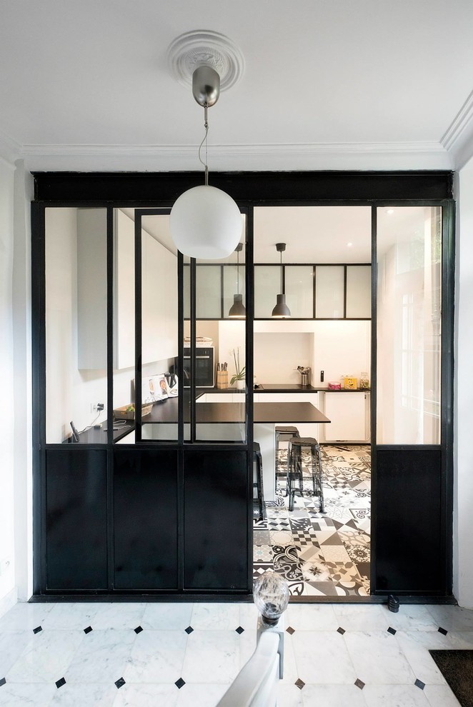 Inspiration for a mid-sized contemporary u-shaped eat-in kitchen in Paris with an undermount sink, solid surface benchtops, white splashback, ceramic splashback, cement tiles, a peninsula, white floor and black benchtop.