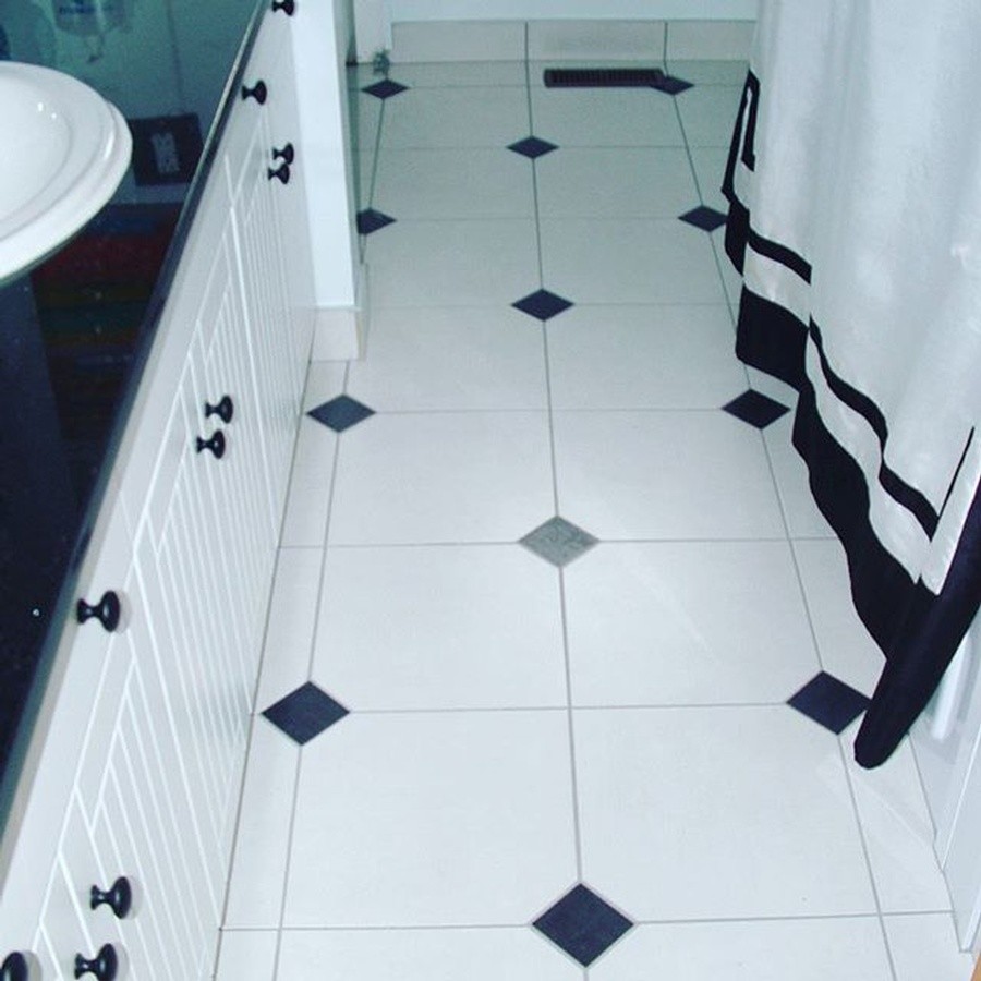 Mid-sized transitional 3/4 ceramic tile and white floor alcove bathtub photo with louvered cabinets, white cabinets, white walls, a drop-in sink and granite countertops