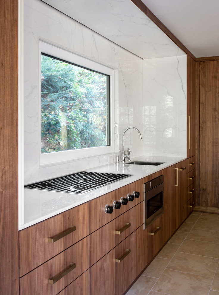 Foto di una cucina moderna di medie dimensioni con lavello sottopiano, ante lisce, ante in legno bruno, paraspruzzi bianco, elettrodomestici da incasso, pavimento in gres porcellanato, pavimento beige e top bianco