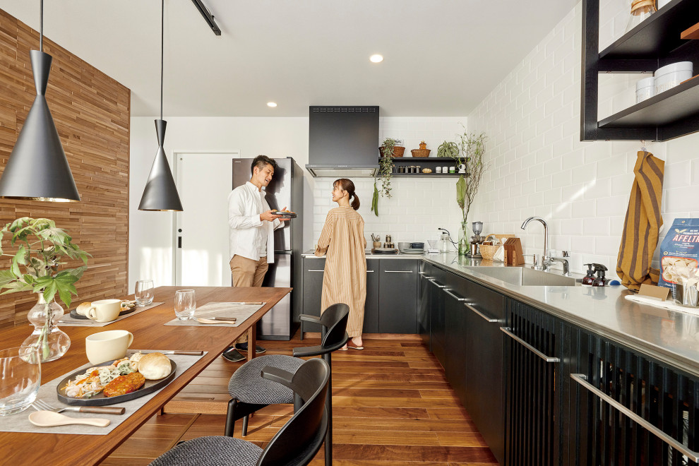Modern inredning av ett litet kök med öppen planlösning, med mellanmörkt trägolv och brunt golv