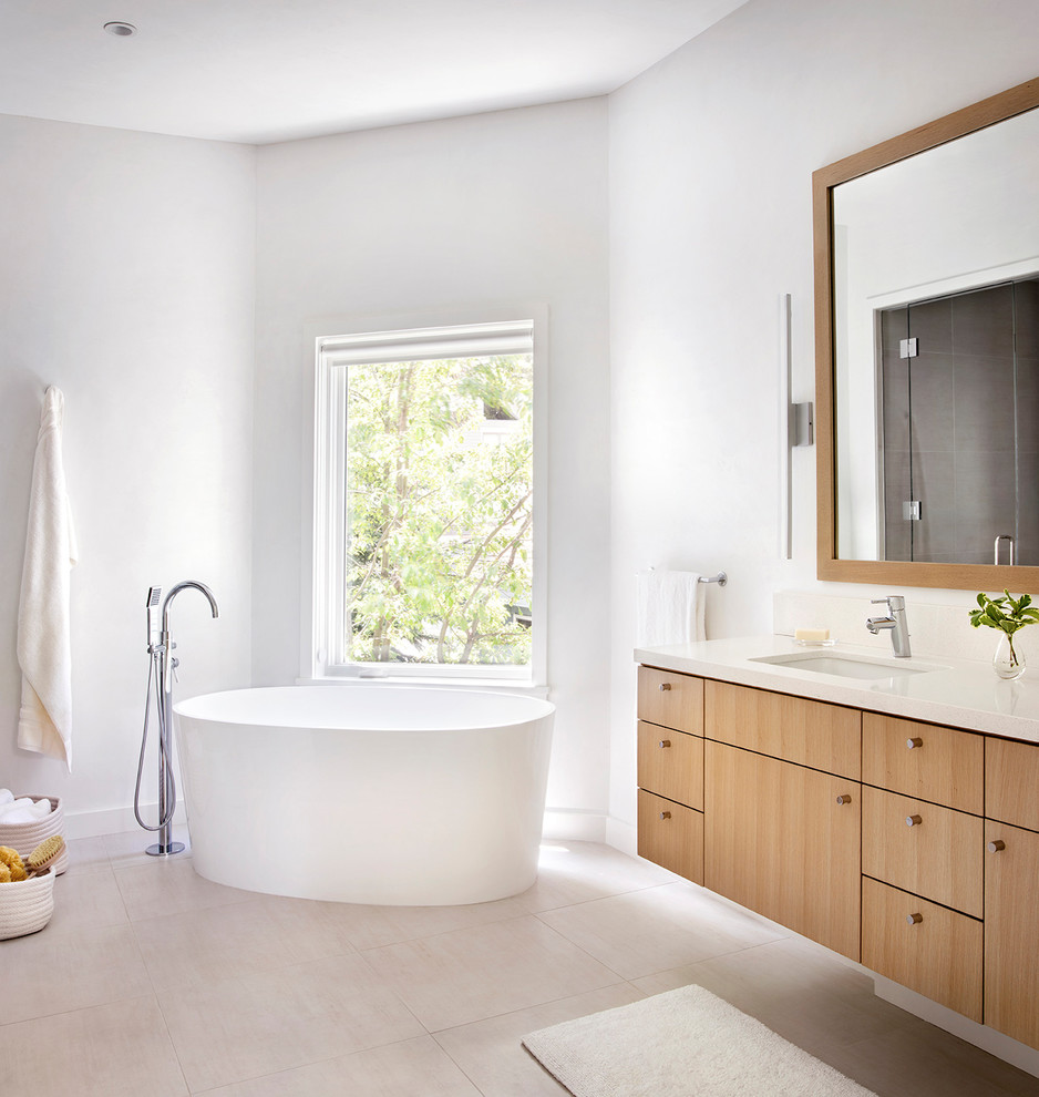 Scandinavian master bathroom with flat-panel cabinets, light wood cabinets, a freestanding tub, grey walls, an undermount sink, beige floor and beige benchtops.