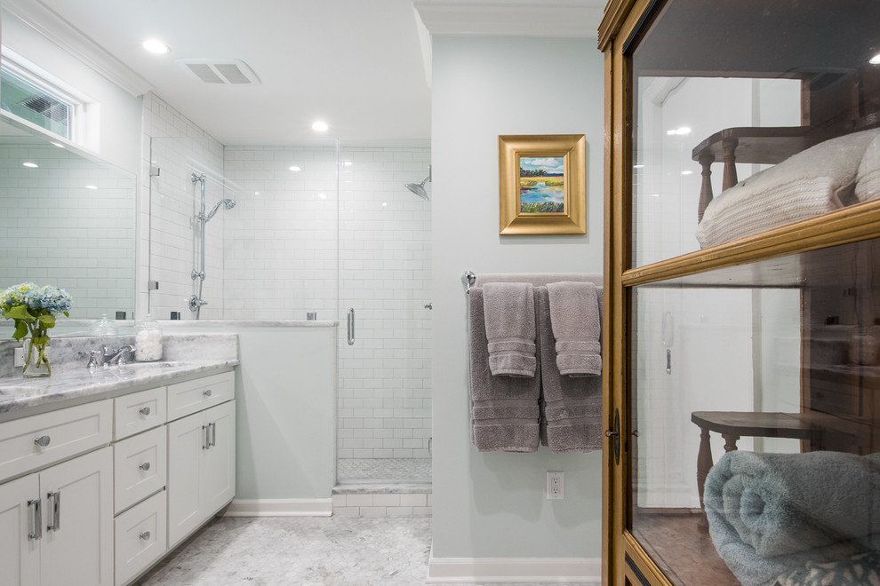 This is an example of a mid-sized traditional master bathroom in Charleston with shaker cabinets, white cabinets, an alcove shower, white tile, subway tile, blue walls, mosaic tile floors, an undermount sink and marble benchtops.