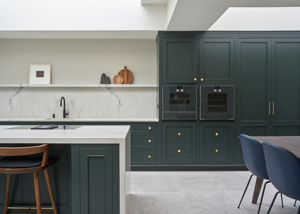 Photo of a transitional galley eat-in kitchen in Dublin with an undermount sink, recessed-panel cabinets, green cabinets, marble benchtops, multi-coloured splashback, marble splashback, black appliances, with island, grey floor and multi-coloured benchtop.
