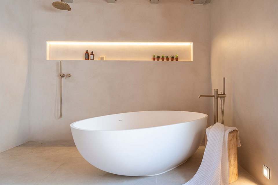 Large contemporary ensuite bathroom in Barcelona with beige cabinets, a wall mounted toilet, ceramic tiles, wooden worktops, double sinks, a floating vanity unit and a vaulted ceiling.
