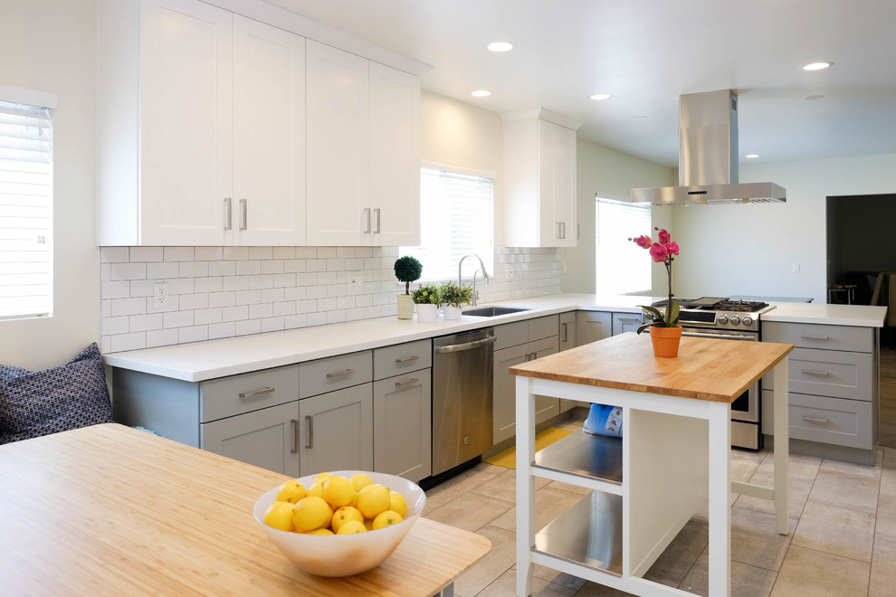Design ideas for a large contemporary l-shaped eat-in kitchen in Los Angeles with a drop-in sink, shaker cabinets, white cabinets, quartz benchtops, white splashback, ceramic splashback, stainless steel appliances, ceramic floors, with island, pink floor and white benchtop.