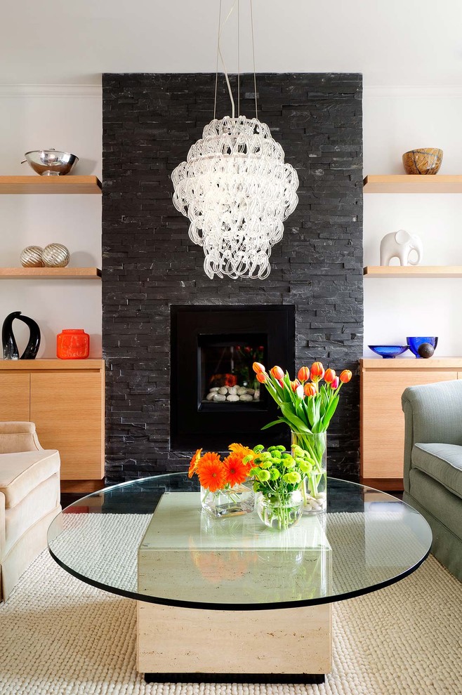 This is an example of a contemporary living room in Toronto with a stone fireplace surround.