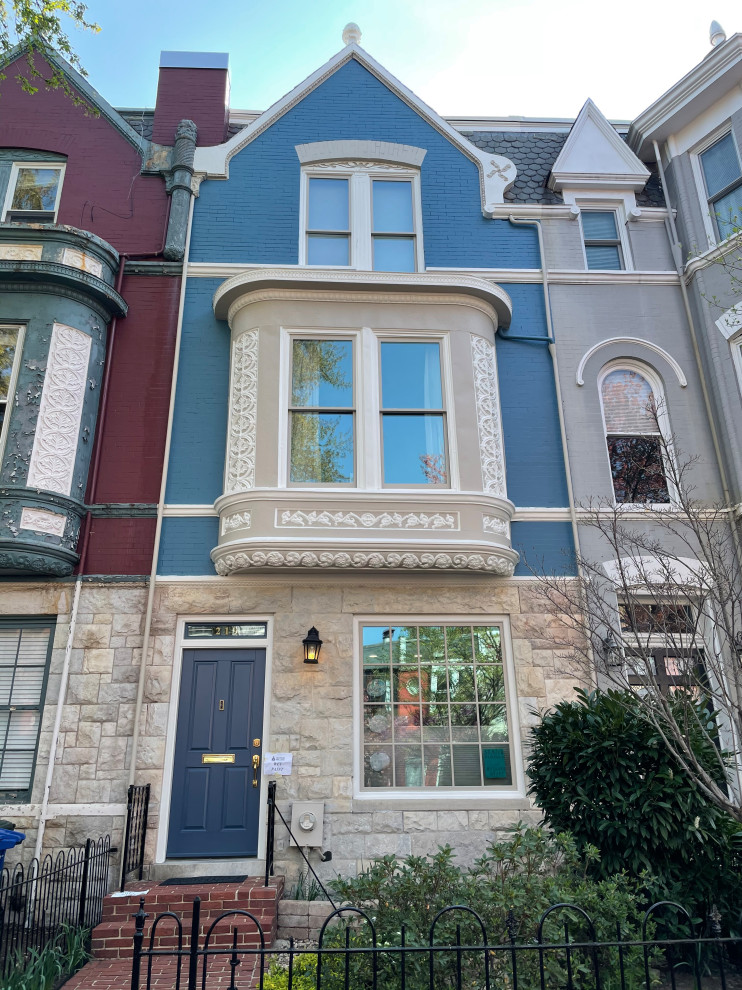 Immagine della facciata di una casa a schiera blu vittoriana a tre piani con copertura in tegole e tetto grigio