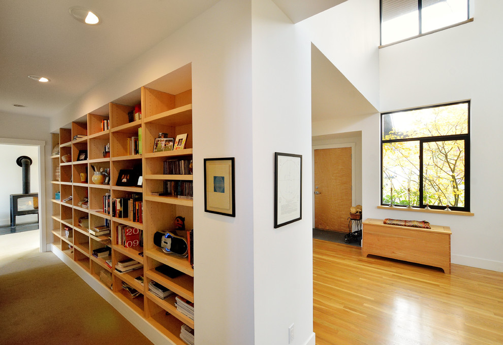 Photo of a large contemporary hallway in Seattle with white walls, medium hardwood floors and yellow floor.