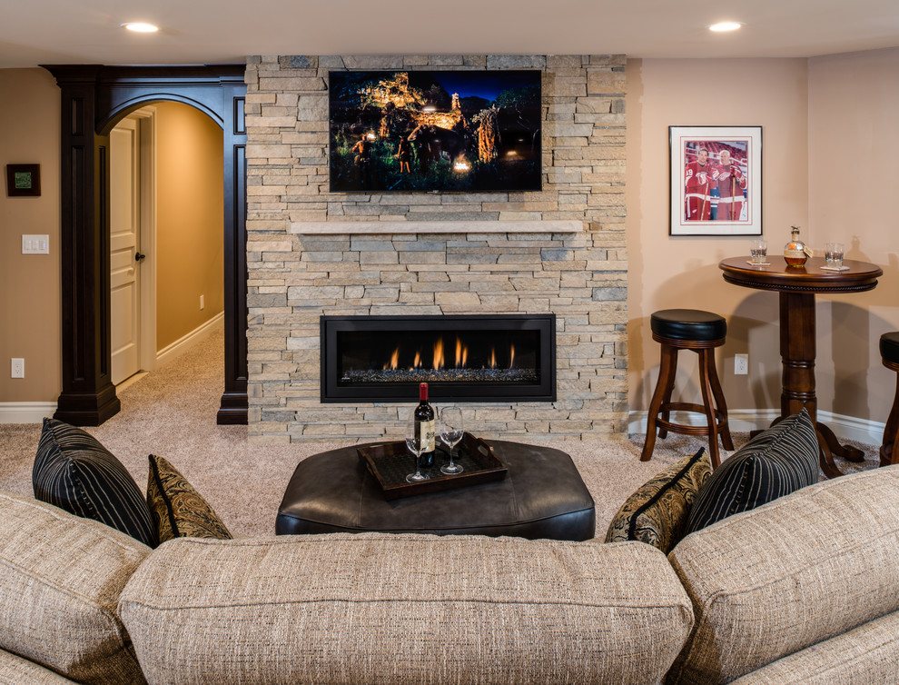 Inspiration for a large transitional walk-out basement in Detroit with beige walls, carpet, a ribbon fireplace, a stone fireplace surround and beige floor.