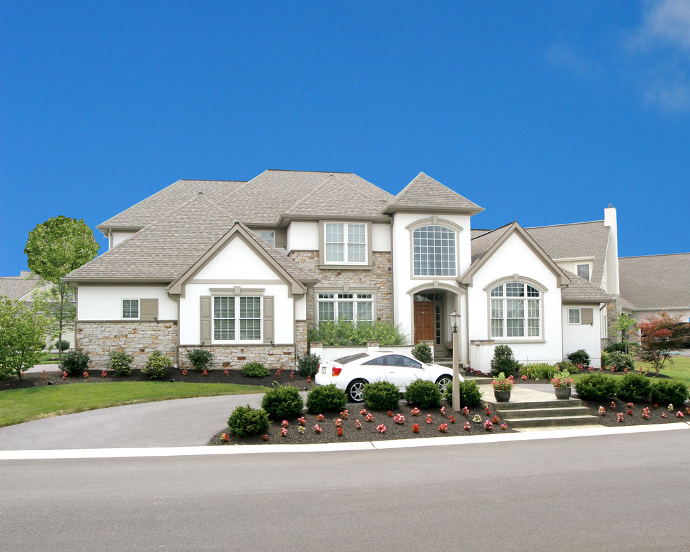 Large trendy two-story white home design photo