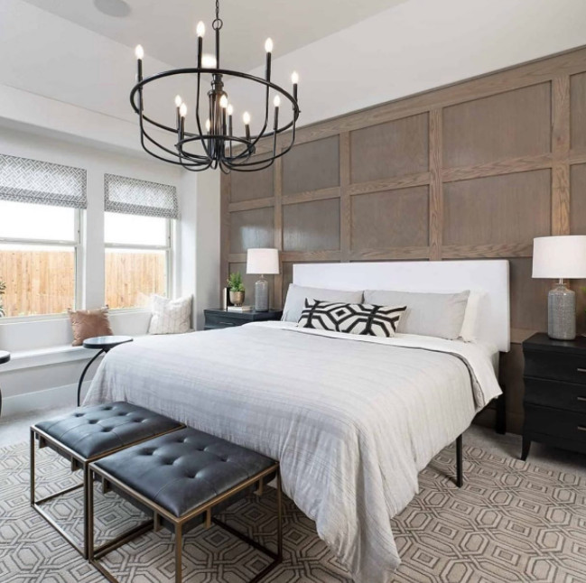 Mittelgroßes Hauptschlafzimmer mit beiger Wandfarbe, hellem Holzboden, braunem Boden und Holzwänden in Dallas
