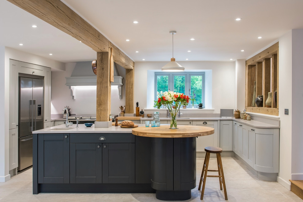 Photo of a country u-shaped separate kitchen in Devon with an undermount sink, shaker cabinets, grey cabinets, white splashback, stainless steel appliances, with island, beige floor and grey benchtop.