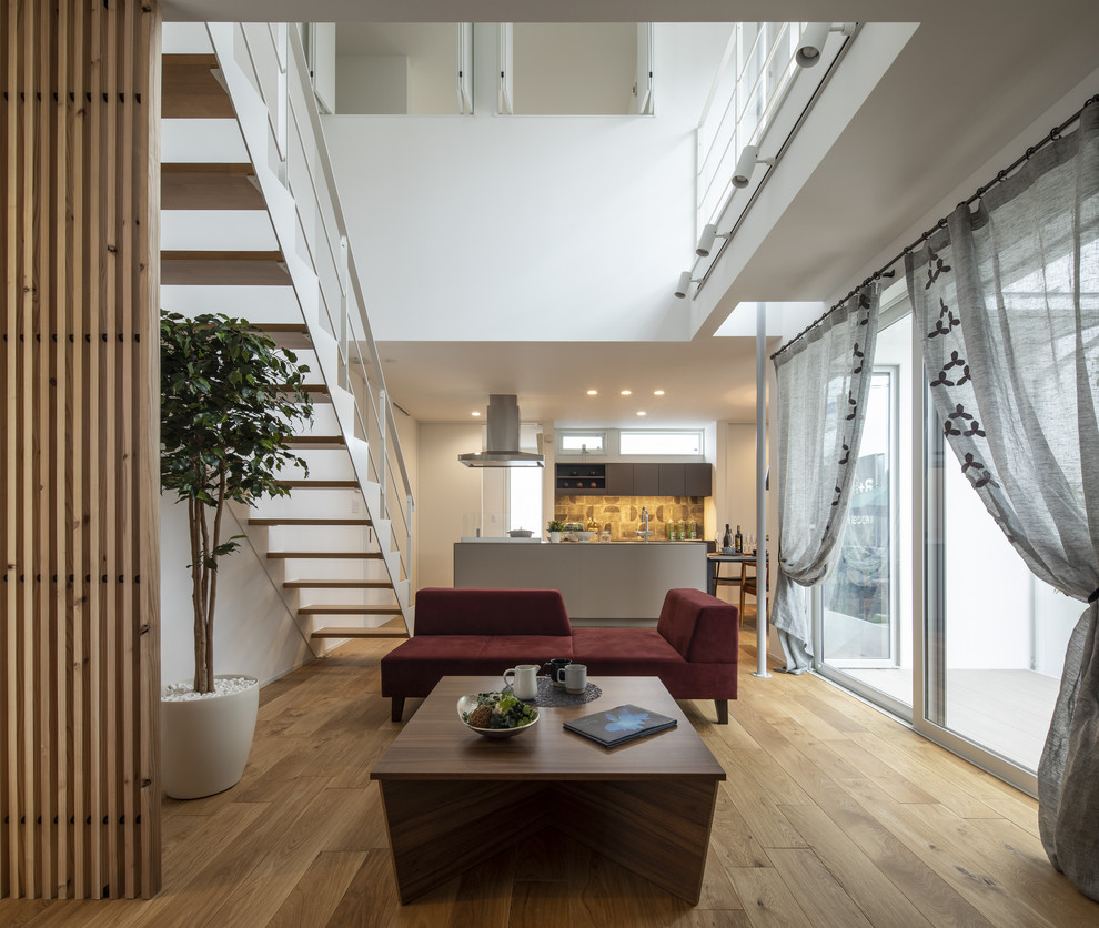 Scandinavian open concept living room in Other with white walls, medium hardwood floors and brown floor.